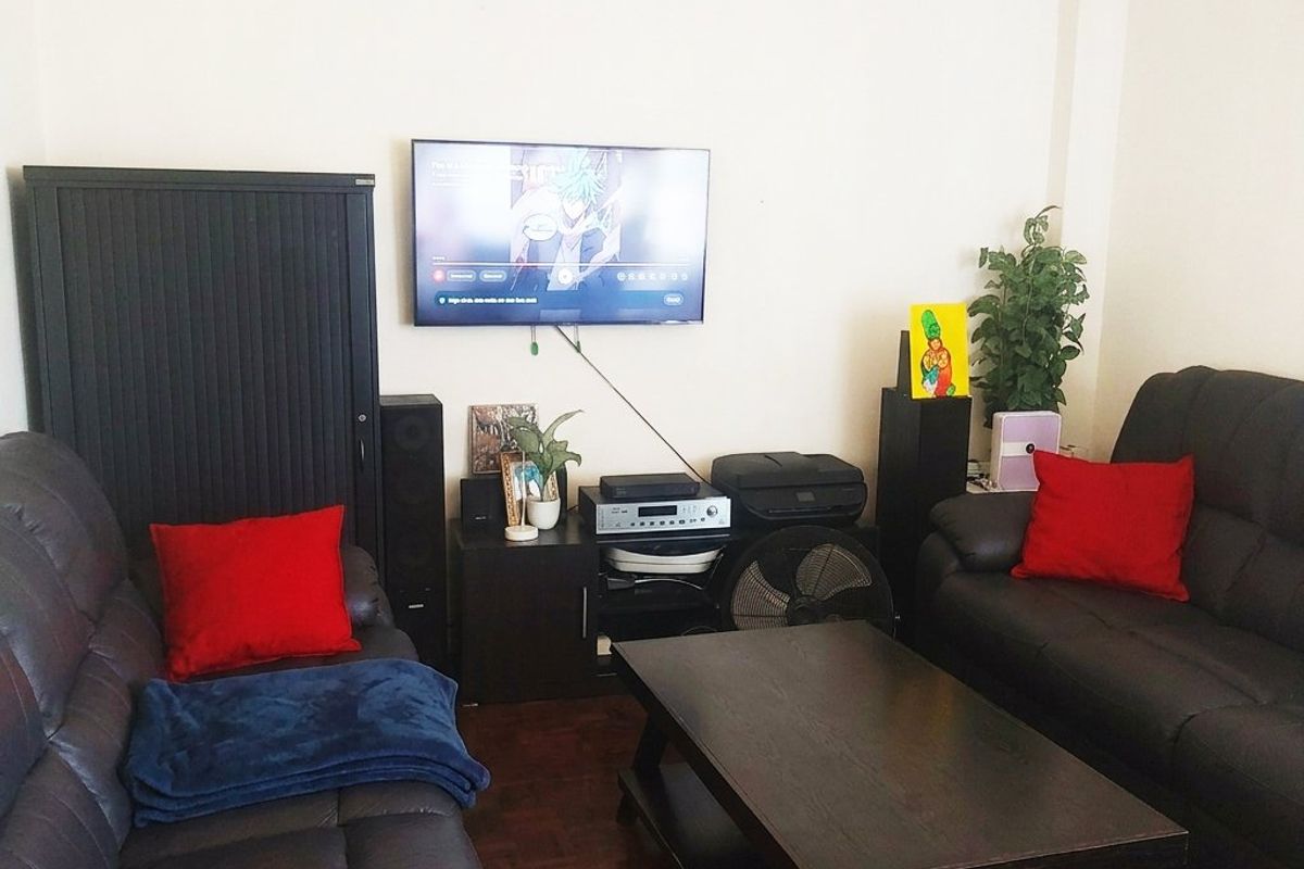 A living room featuring dark parquet flooring and neutral wall finishes, providing a functional space for relaxation and entertainment.