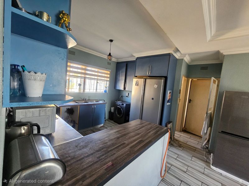 A functional kitchen featuring blue cabinetry, a wood-look laminate countertop, double sink, and tiled flooring, requiring some cosmetic updates to the cabinetry.