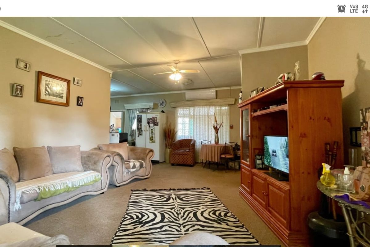 Spacious living area featuring a ceiling fan, split-system air conditioning, and tiled ceiling panels, offering a functional layout for relaxation.