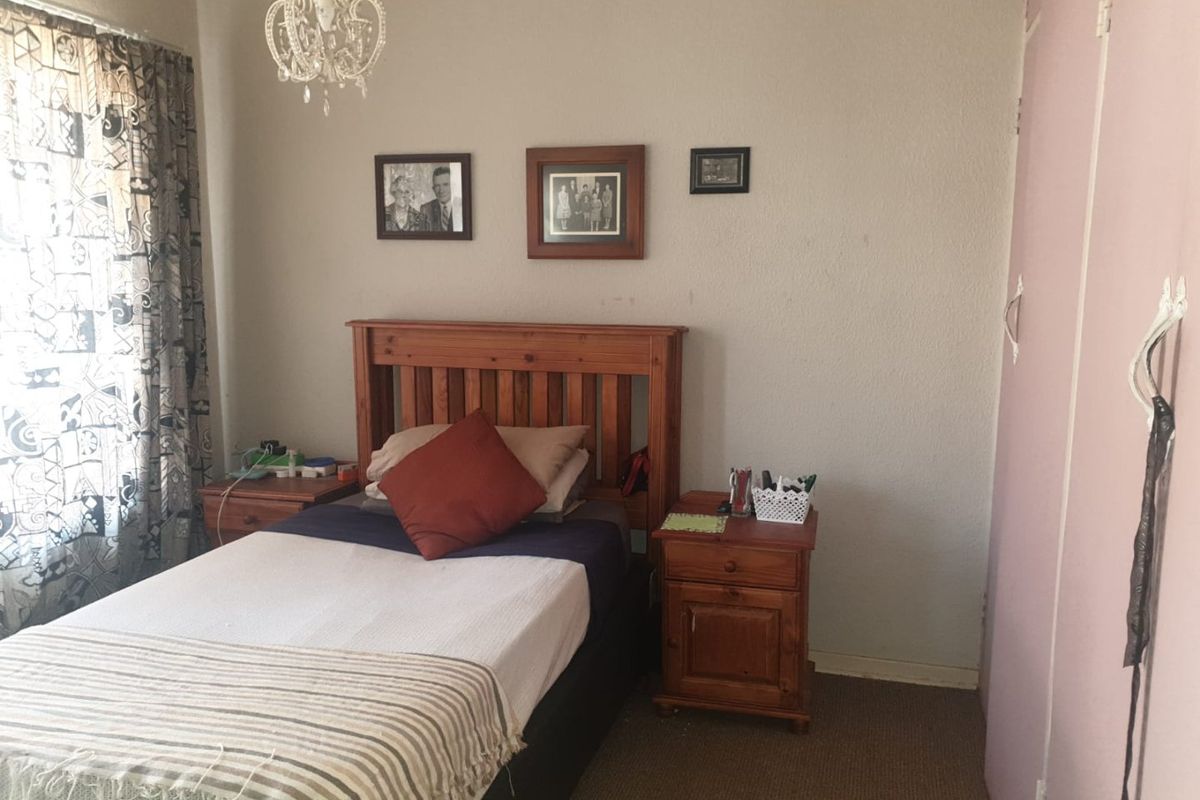A standard bedroom featuring carpeted flooring and a built-in wardrobe, providing a functional living space.