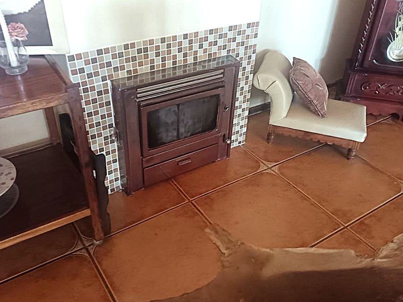 Living room area featuring a built-in fireplace with a mosaic tile surround and ceramic floor tiling.