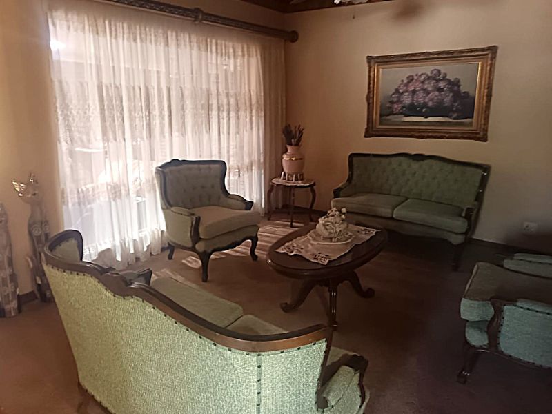 A traditional living room featuring a timber ceiling, ceiling fan, and large sliding glass doors that provide ample natural light.