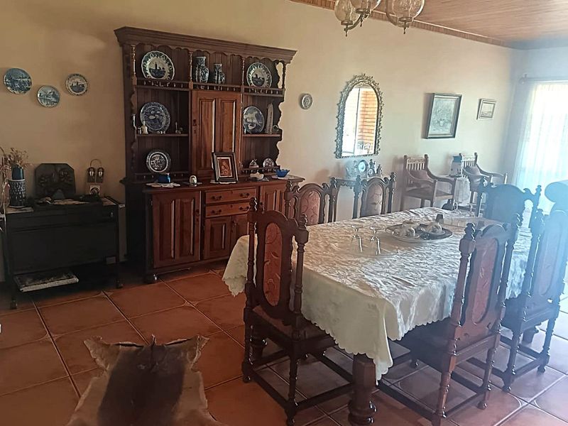 A traditional dining room featuring terracotta floor tiles and a timber tongue and groove ceiling, offering a classic and warm atmosphere.