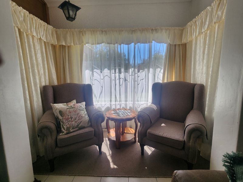 A cozy seating area featuring a large bay window that allows for ample natural light.