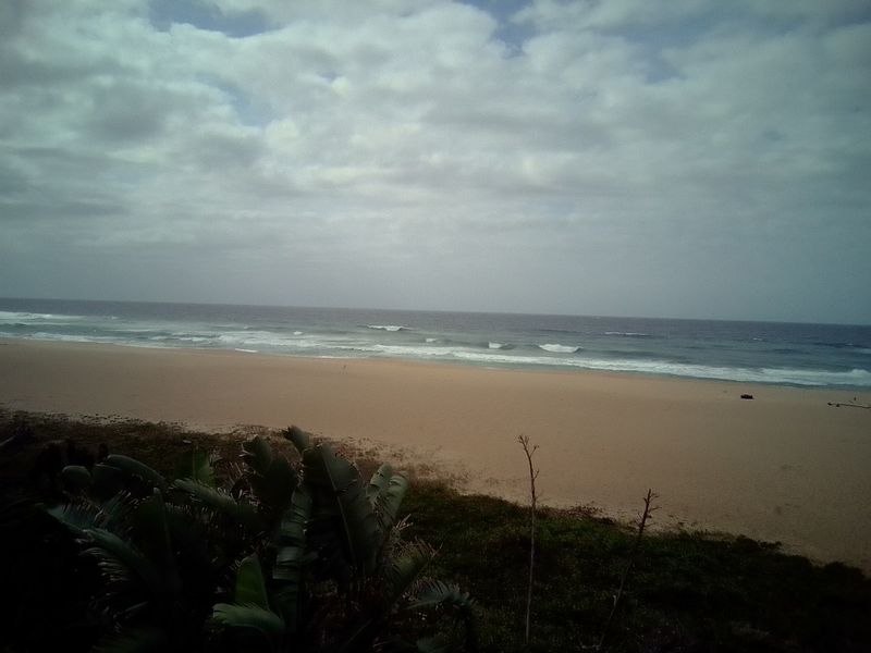 A scenic view of the sandy beach and ocean waves captured from the property.