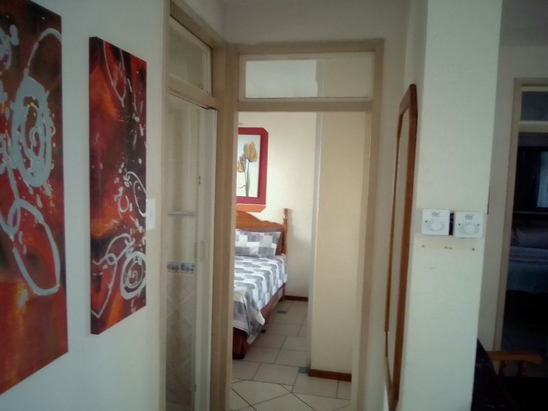 A functional hallway connecting interior rooms, featuring tiled flooring and standard door frames with transom windows.