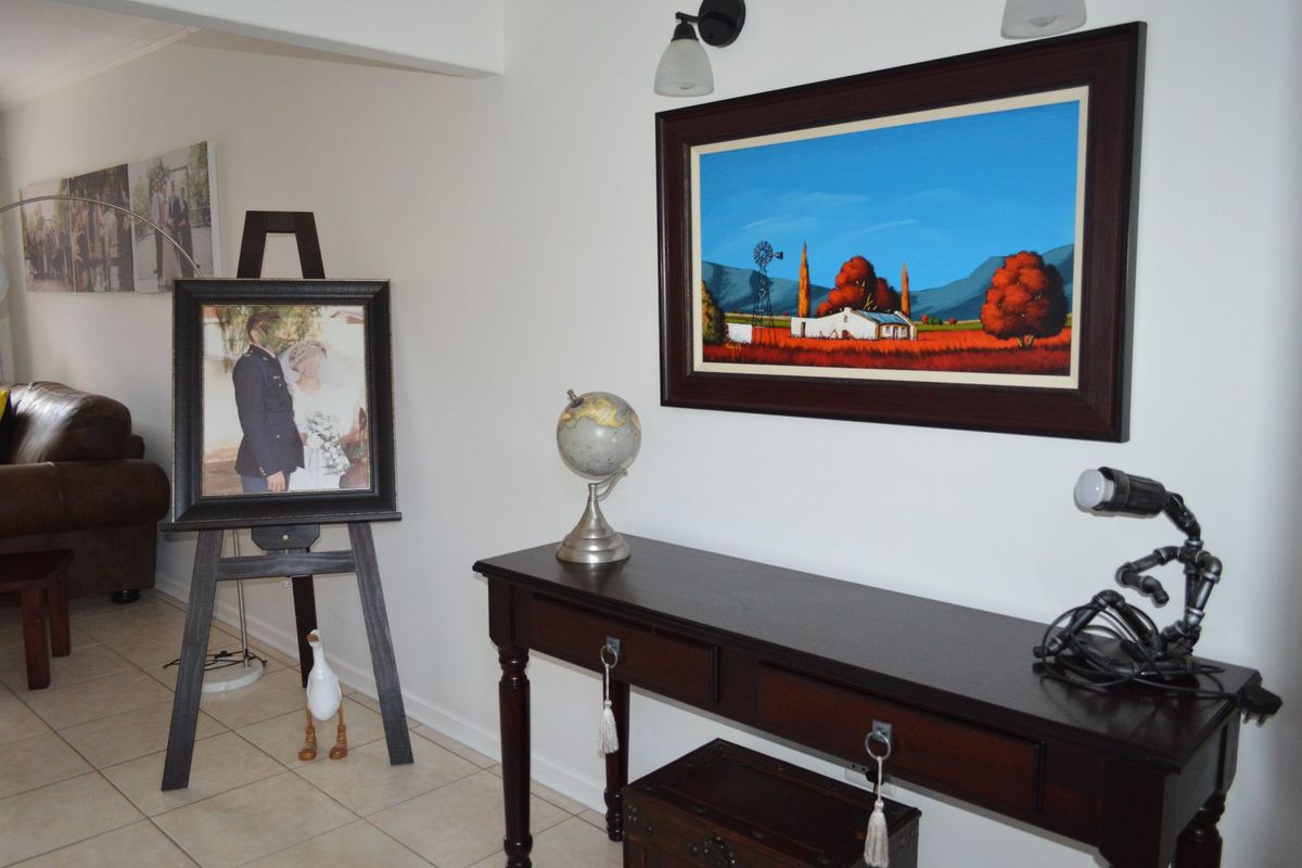 A well-maintained living area featuring neutral tiled flooring and wall-mounted lighting fixtures, providing a clean and functional space.