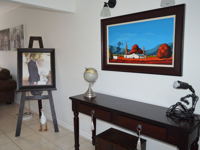 A well-maintained living area featuring neutral tiled flooring and wall-mounted lighting fixtures, providing a clean and functional space.