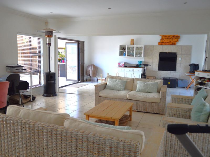 Spacious open-plan living area featuring tiled floors, a built-in fireplace, and direct access to the outdoor patio through sliding glass doors.