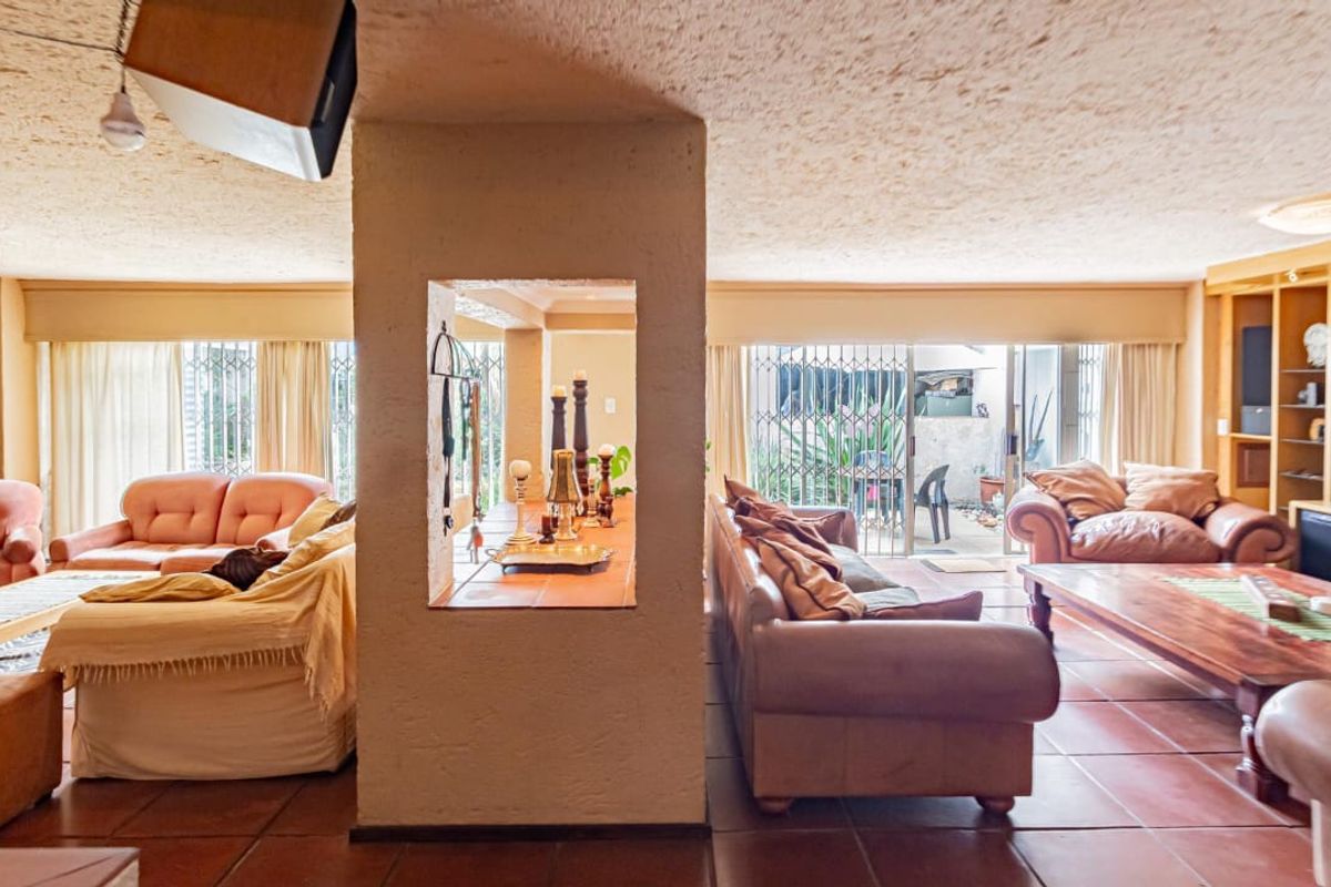 Spacious living area featuring tiled flooring, a central structural pillar with a display cutout, built-in shelving, and sliding doors leading to the exterior.