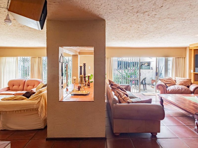 Spacious living area featuring tiled flooring, a central structural pillar with a display cutout, built-in shelving, and sliding doors leading to the exterior.