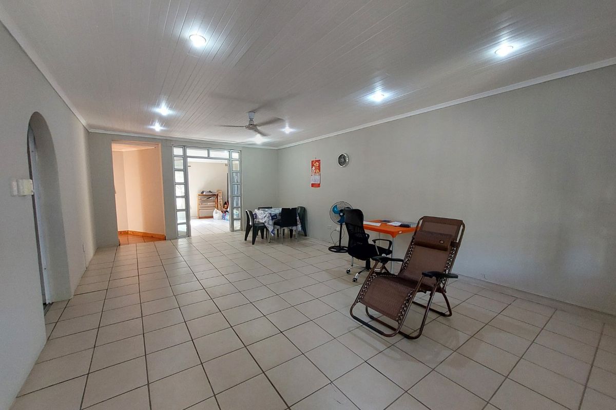 Spacious open-plan living area featuring tiled flooring, recessed ceiling lighting, and a ceiling fan, providing a versatile space for relaxation or dining.