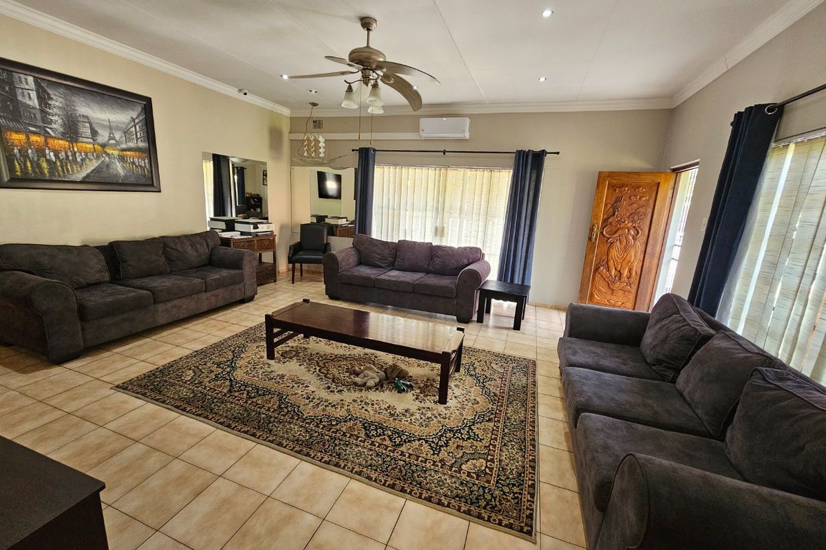 Spacious living room featuring tiled flooring, a ceiling fan, split-system air conditioning, and access to the outdoors via a sliding glass door.