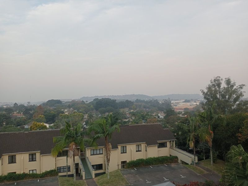 Elevated view overlooking the apartment complex grounds, parking area, and surrounding suburban landscape.