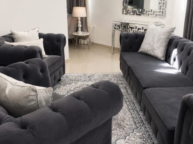 A well-maintained living room featuring neutral tiled flooring and clean wall finishes, providing a bright and comfortable space for relaxation.