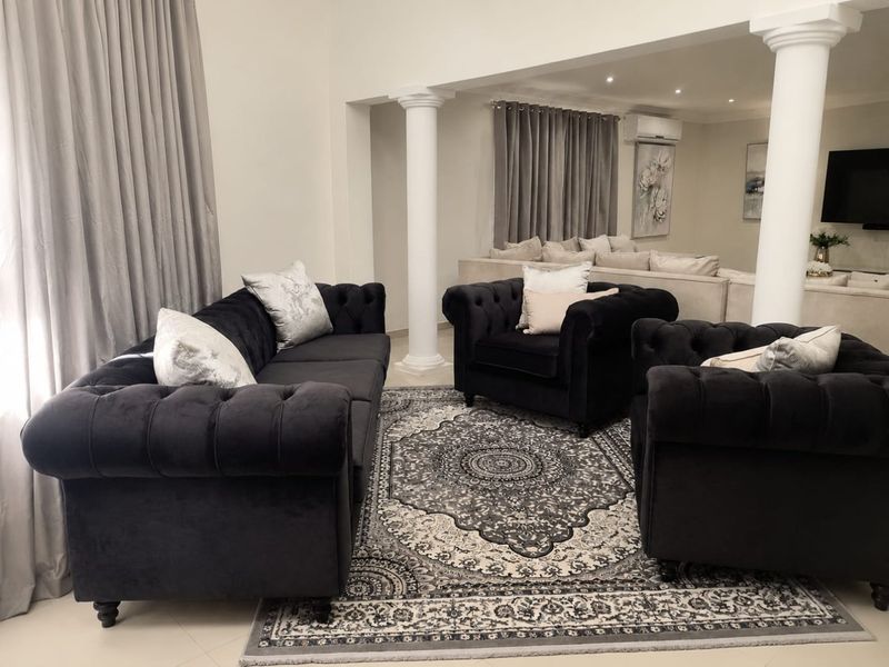 Spacious living area featuring structural columns, recessed downlighting, and split-system air conditioning, creating an open and well-defined lounge space.