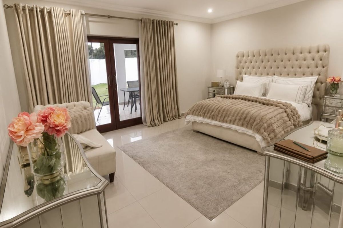 Spacious bedroom featuring neutral tiled flooring, recessed downlighting, and a sliding glass door providing direct access to the outdoor patio area.