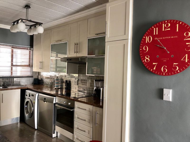 A well-maintained kitchen featuring cream cabinetry, granite countertops, stainless steel appliances, and a tiled backsplash, offering a functional and modern cooking space.