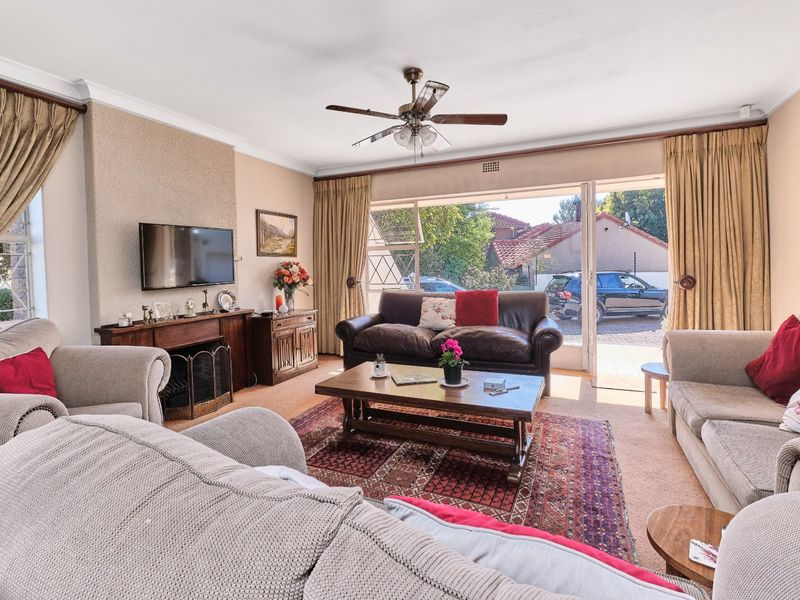 Spacious living room featuring a fireplace, ceiling fan, and large sliding glass doors providing access to the exterior.