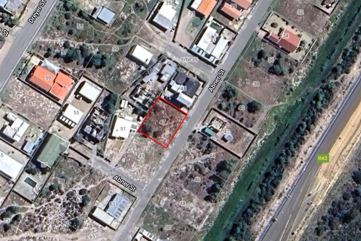 Aerial view showing the vacant residential plot highlighted in red, situated within an established neighborhood with street access.