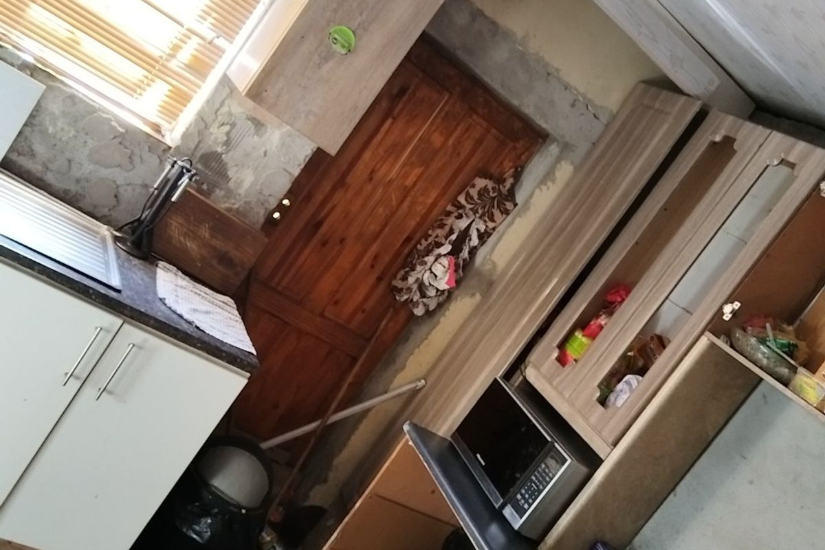 A kitchen space featuring built-in cabinetry, a gas hob, and oven, currently requiring significant wall finishing and renovation to complete the interior.