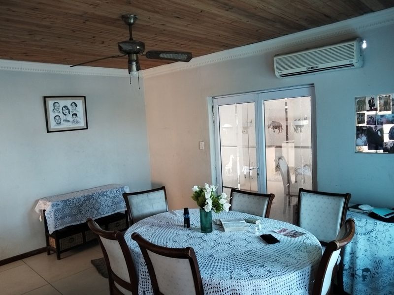Dining room featuring a timber ceiling, ceiling fan, split-system air conditioner, and glass sliding doors leading to an outdoor area.