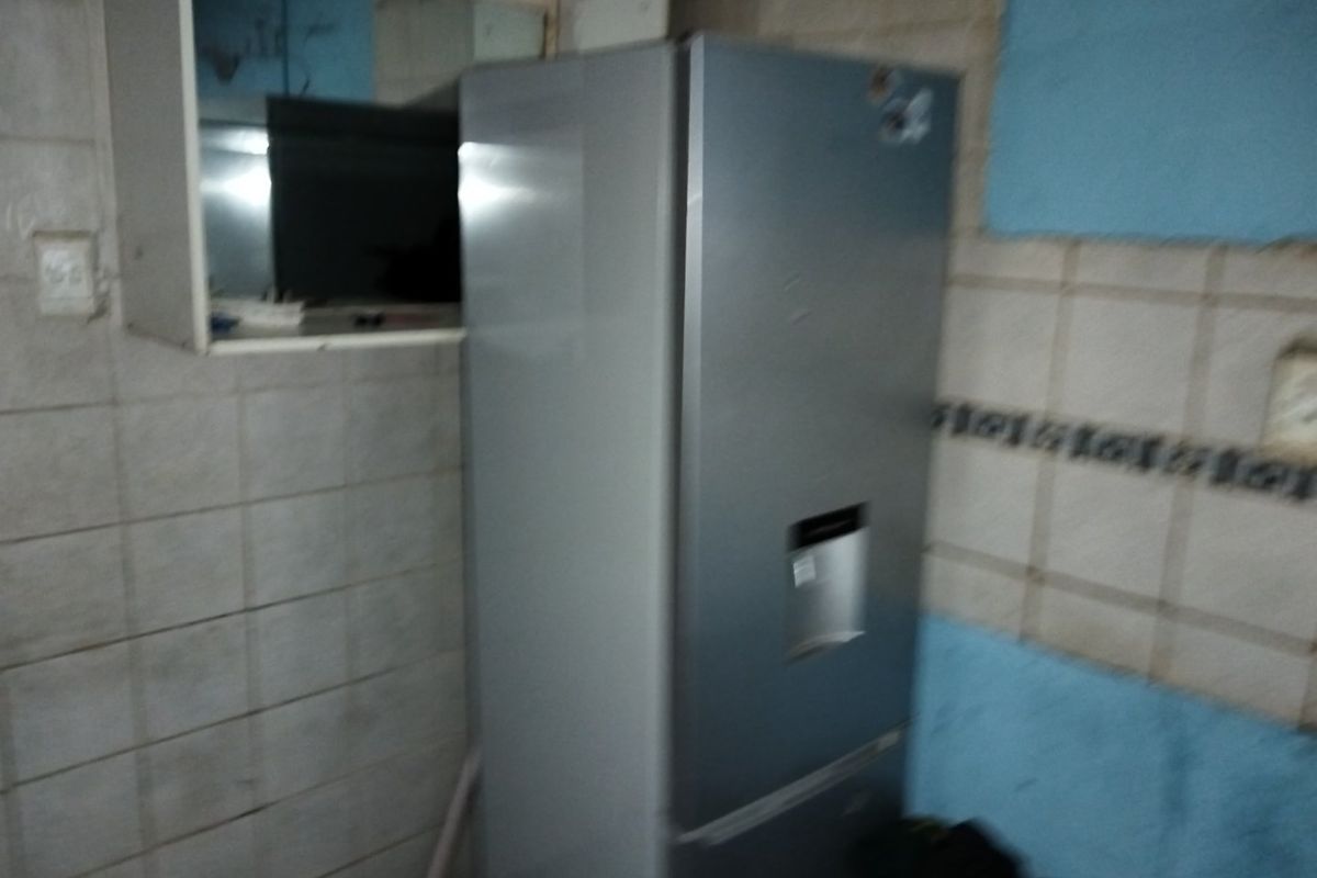 A kitchen area featuring tiled walls and visible signs of wear, requiring maintenance and cosmetic updates to improve the overall condition.