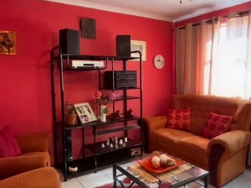 A living room featuring tiled flooring, a ceiling fan, and cove cornicing, currently styled with bold wall colors.