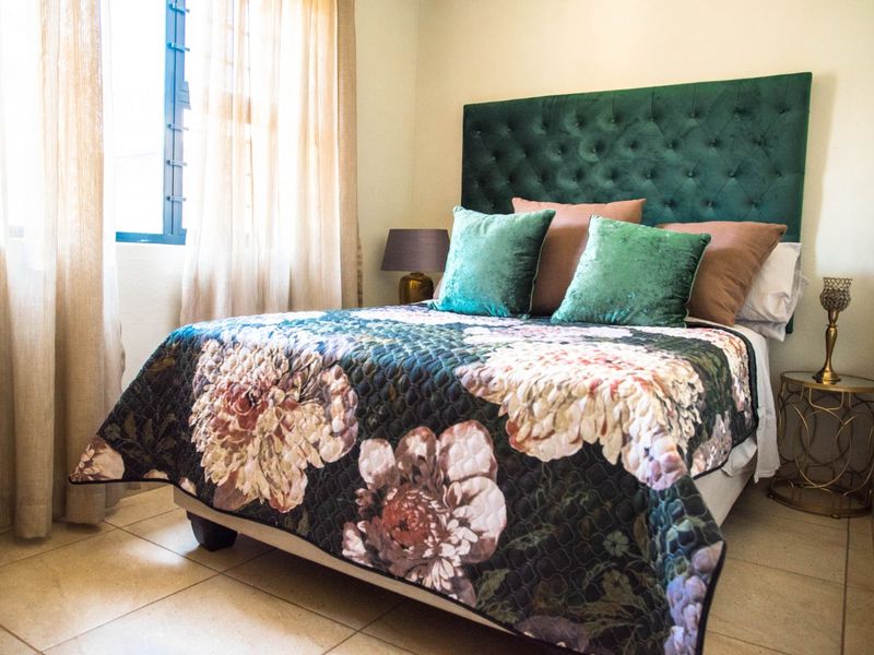 A well-maintained bedroom featuring tiled flooring and a window, providing a comfortable and functional living space.