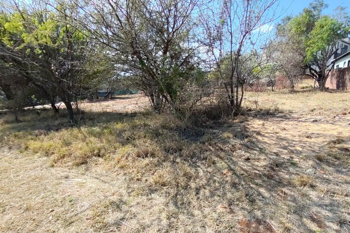 A view of the residential vacant land featuring mature trees and natural vegetation across the plot.