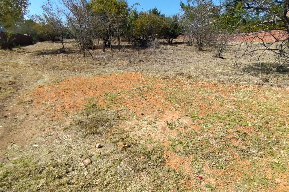 A view of a vacant residential plot featuring natural vegetation and cleared ground, suitable for future development.