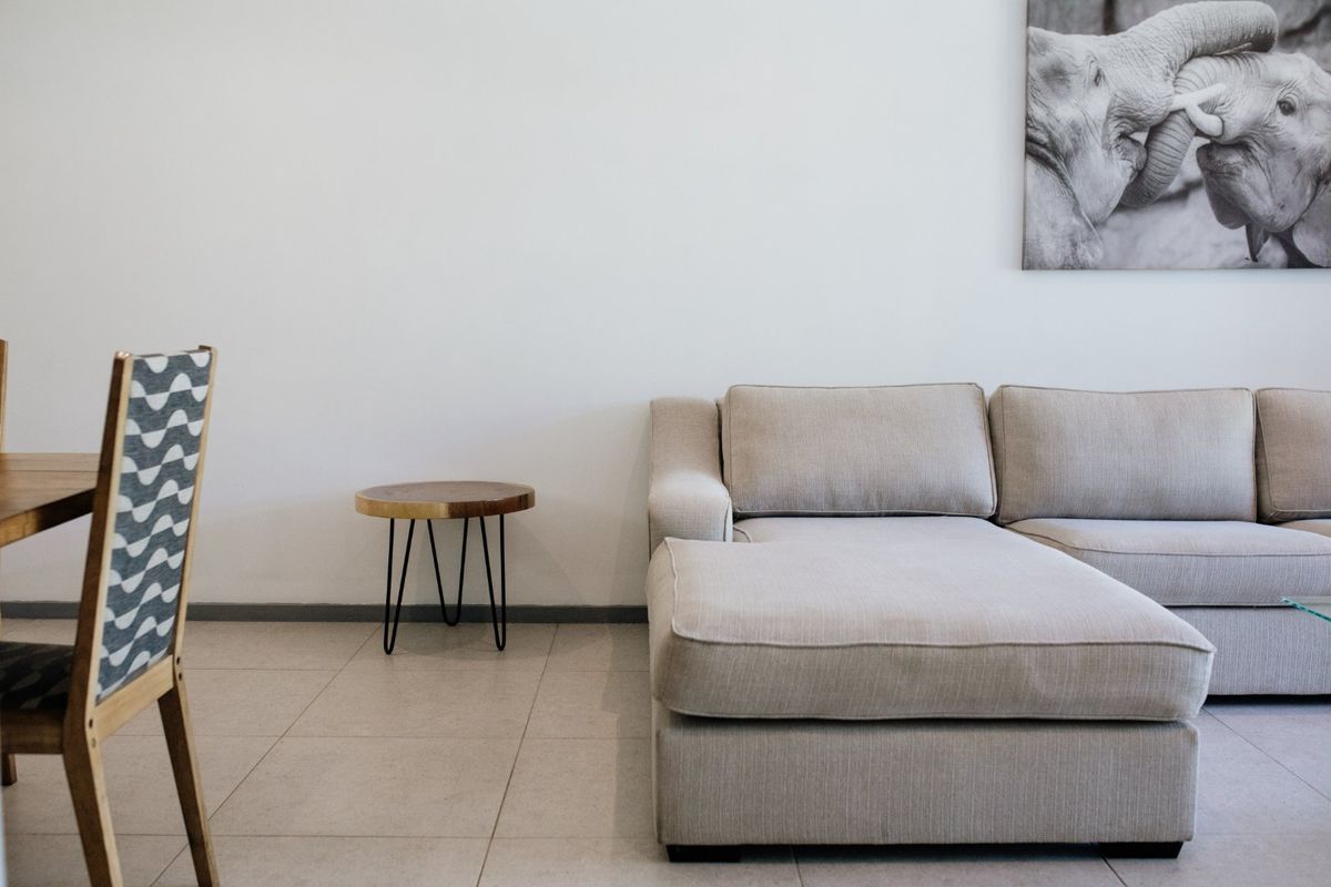 A well-maintained living area featuring neutral tiled flooring and clean wall finishes, providing a bright and comfortable space.