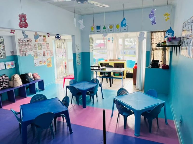 A multi-purpose room currently utilized as a childcare or educational space, featuring painted walls and a multi-level floor surface.