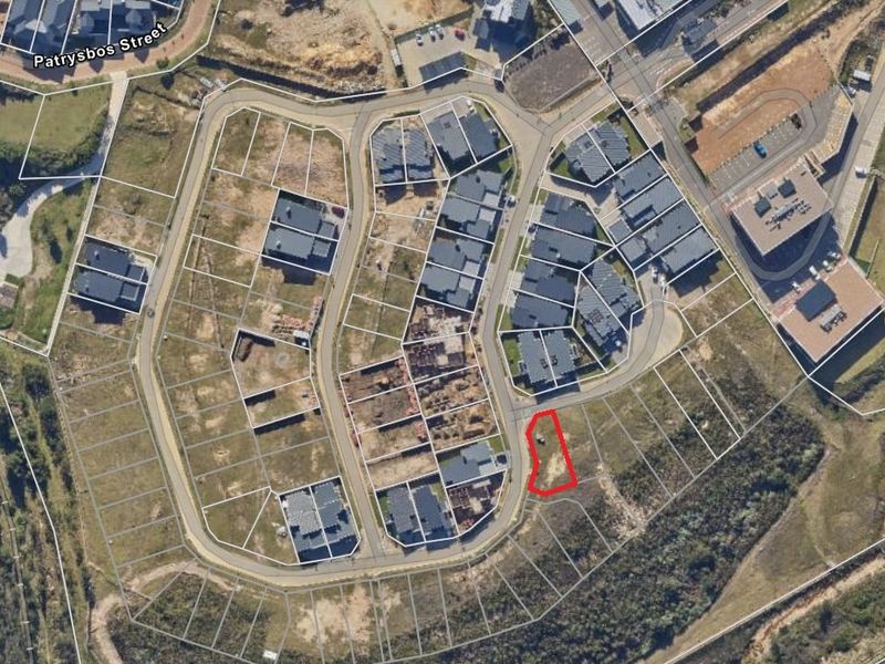 Aerial view of a vacant residential plot within a developed estate, highlighting its location, road access, and surrounding neighborhood context.