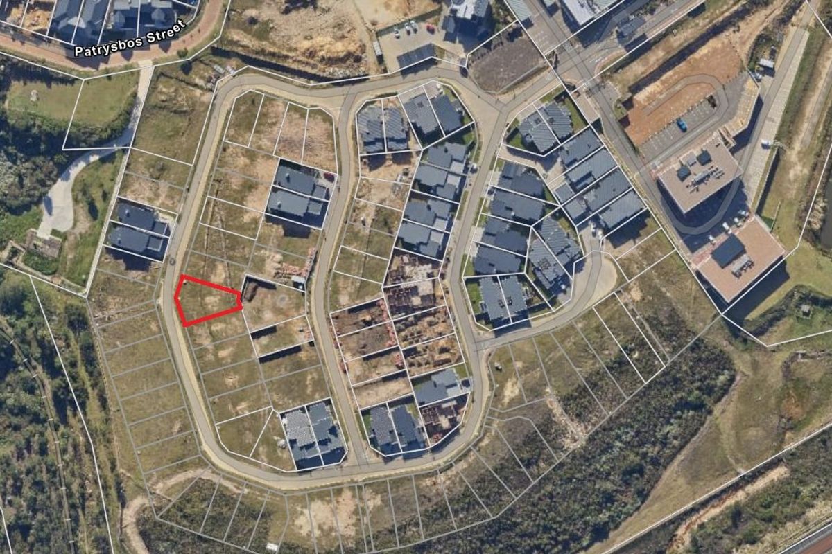Aerial view of a vacant residential plot within a developed estate, highlighting the site boundaries and surrounding infrastructure.