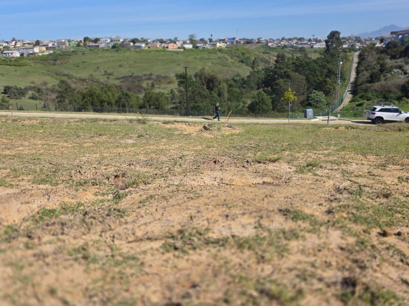 A view of the vacant residential land showing the sloped terrain and surrounding neighborhood landscape.
