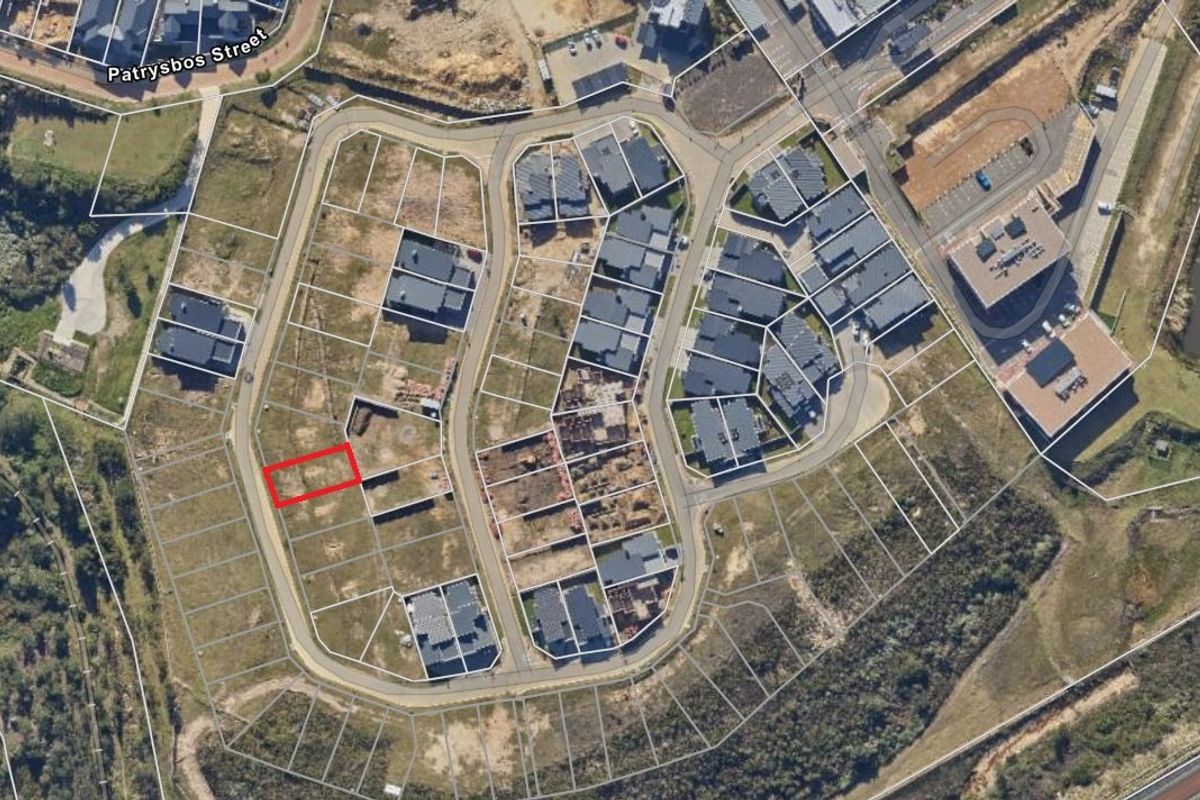 An aerial view of a residential estate showing a vacant plot highlighted in red within a developed neighborhood.