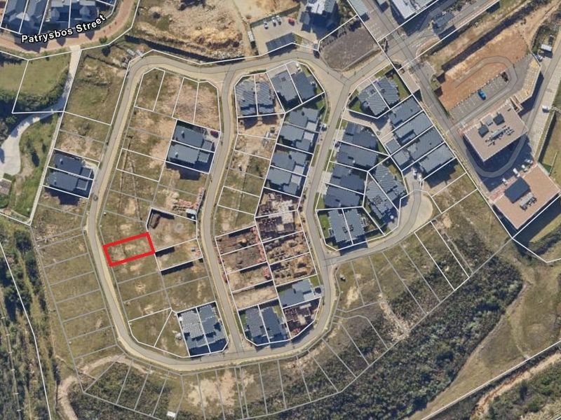 An aerial view of a residential estate showing a vacant plot highlighted in red within a developed neighborhood.