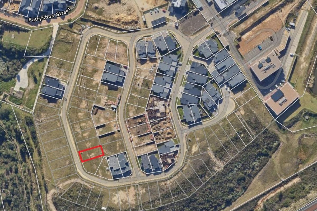 Aerial view of a residential estate showing the vacant land plot highlighted in red within the established street layout.