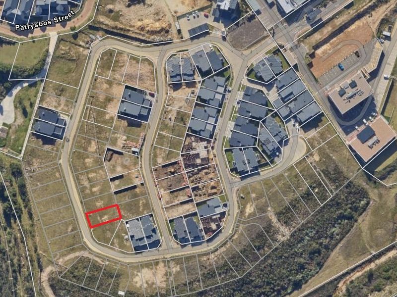 Aerial view of a residential estate showing the vacant land plot highlighted in red within the established street layout.
