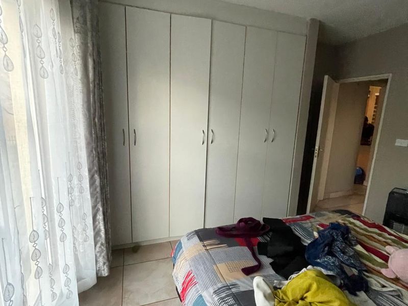 A bedroom featuring built-in cupboards and tiled flooring, providing functional storage space within the apartment.