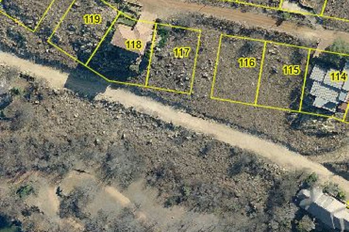 Aerial view of residential vacant land plots with property boundaries overlaid, situated near a water body and existing residential development.