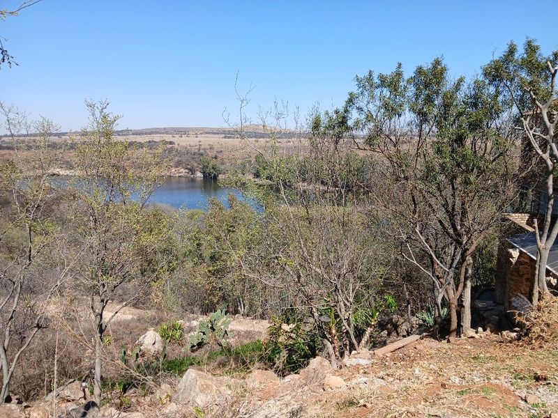 A scenic view overlooking a natural water body and surrounding landscape, showcasing the property's tranquil outdoor setting.