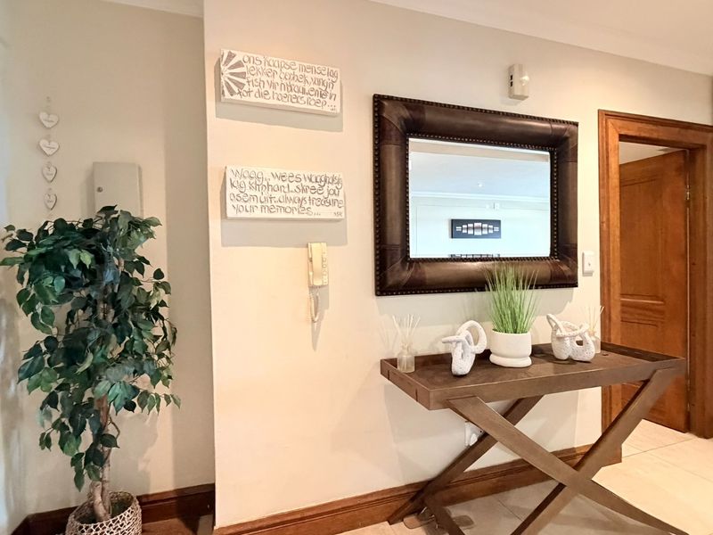 A welcoming apartment entrance hall featuring tiled flooring, neutral walls, and a built-in cupboard, providing a clean and functional transition space.