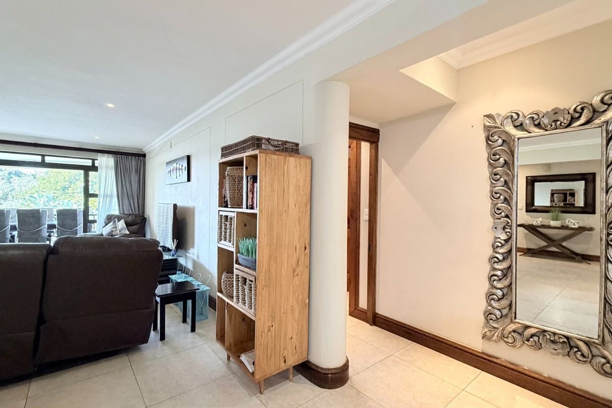 Spacious living area featuring tiled flooring, recessed lighting, and large sliding glass doors leading to an outdoor balcony space.