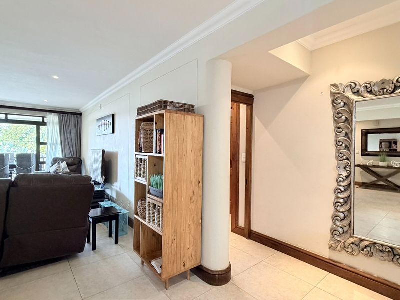 Spacious living area featuring tiled flooring, recessed lighting, and large sliding glass doors leading to an outdoor balcony space.
