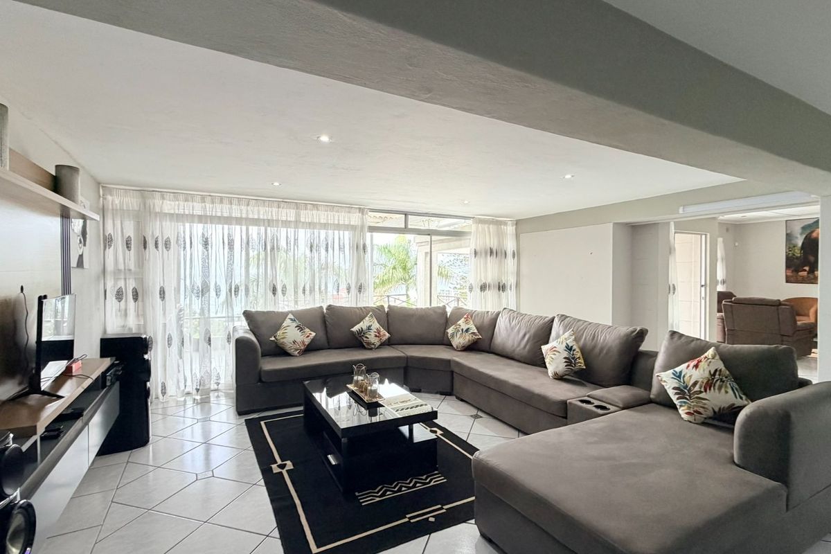 Spacious living room featuring tiled flooring, recessed lighting, and large sliding glass doors that provide natural light and access to the outdoor area.