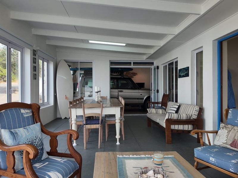 A spacious, enclosed patio area featuring tiled flooring, exposed beam ceilings, and large sliding glass doors providing ample natural light.