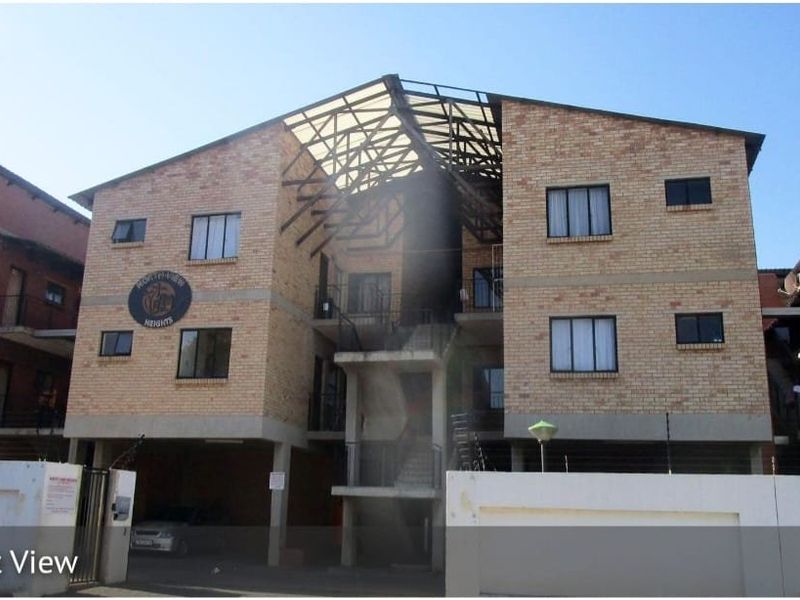 Front elevation of Northview Heights townhouse complex featuring face brick construction, central concrete staircase, and perimeter security fencing.
