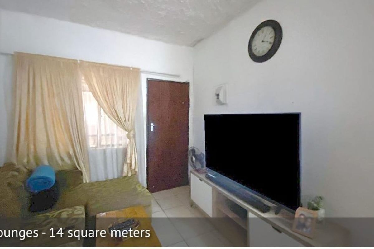 A compact living room featuring tiled flooring, a window with curtains, and a standard door, providing a functional space for relaxation.
